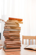 Stack books or textbooks and one opened book on wooden desk in room. Literature research. Concept - information search in books. Back to school. Education and school concept. copy space
