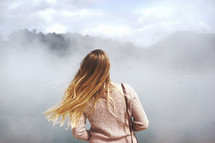 a woman standing in fog 
