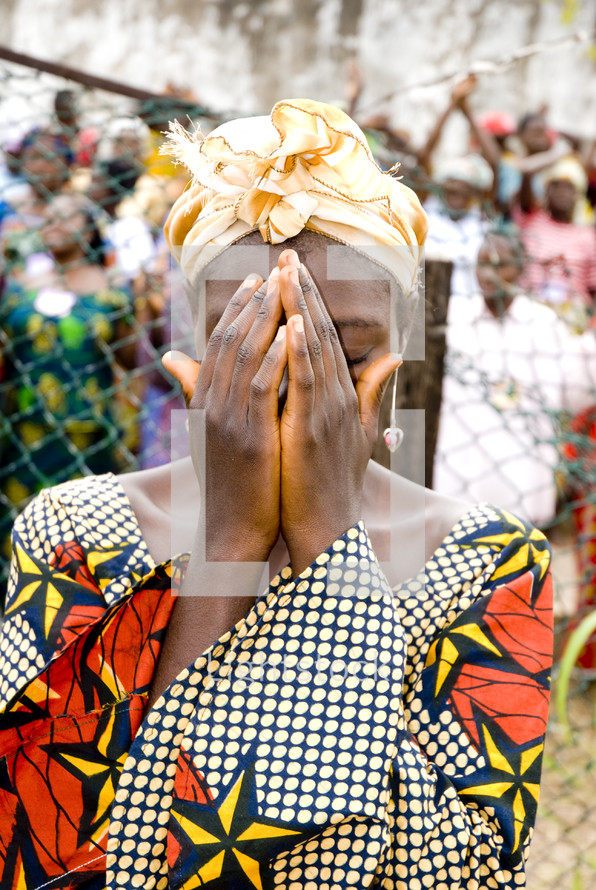 An African woman in tribal dress in prayer
