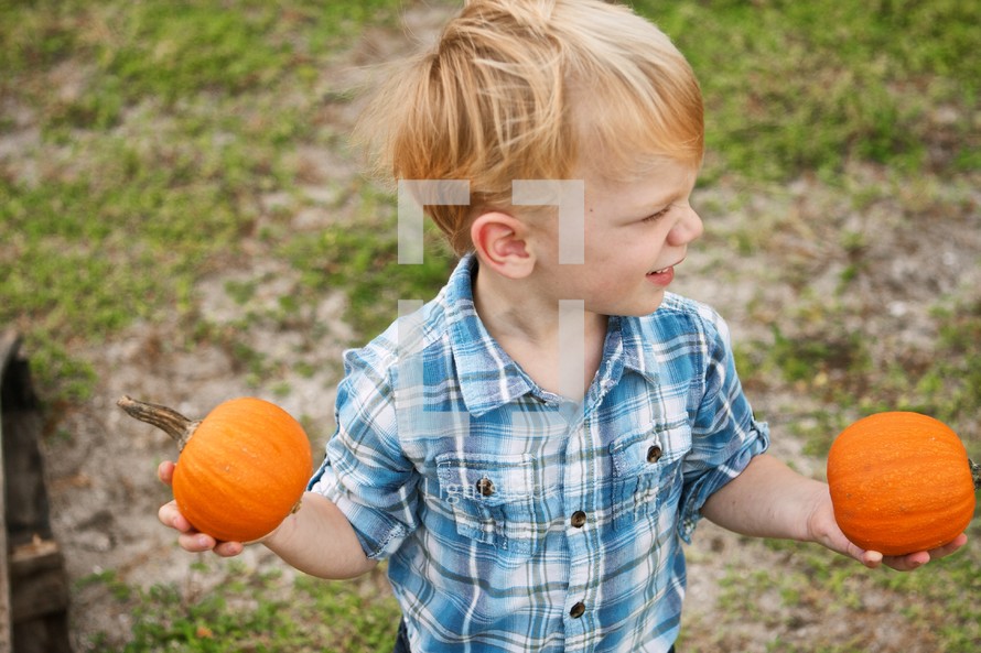 Boy holding two pumpkins