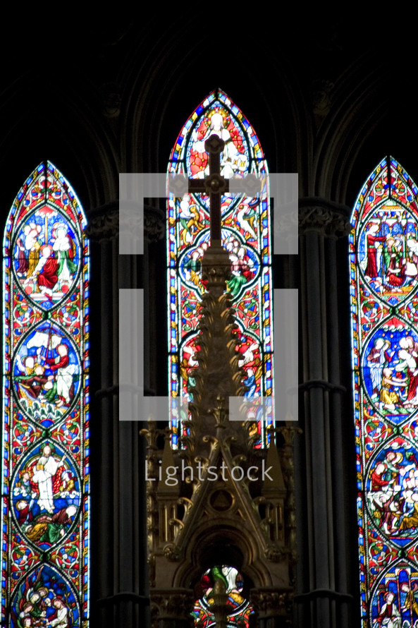 cross and stained glass windows in a Cathedral