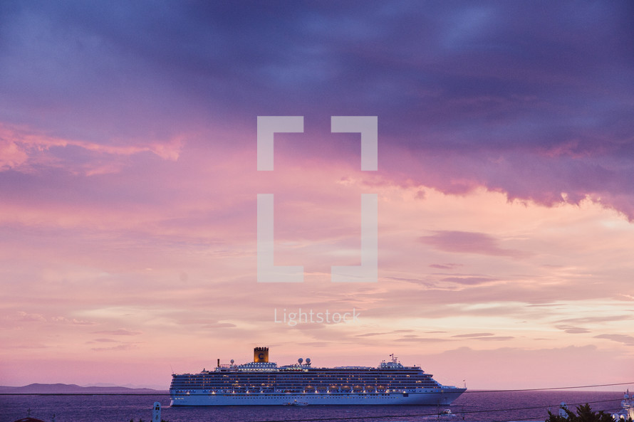 A cruise ship on the ocean at dusk.