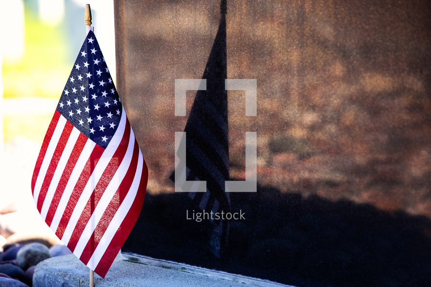 grave markers in a cemetery and American flags 