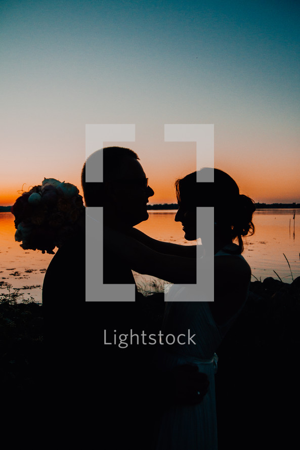 silhouette of a bride and groom at sunset 