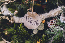 Wooden ornament with the word "the Truth" on a Christmas tree 