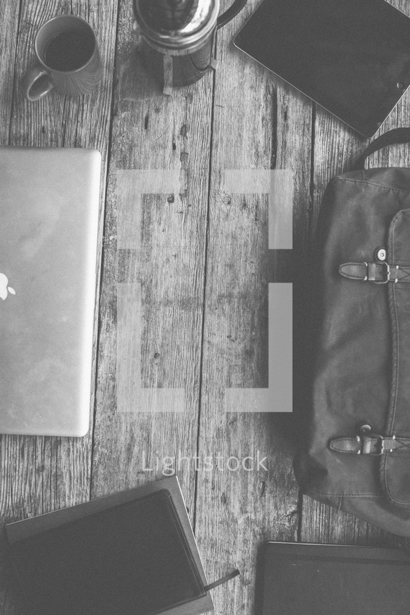 Laptop, bag, notebooks, Bible and coffee on a table