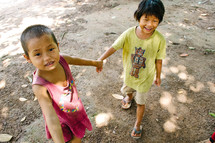 young children holding hands outdoors 
