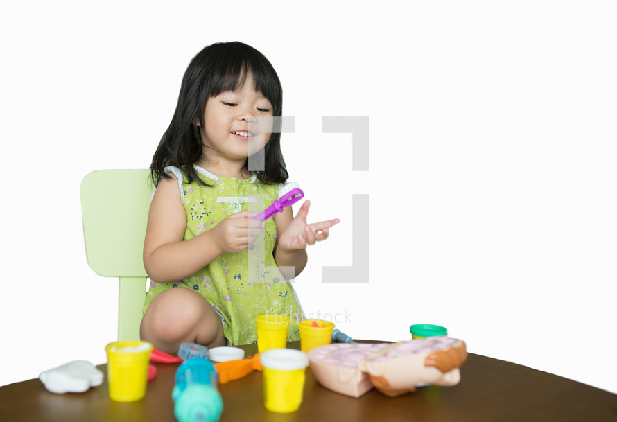 a toddler girl playing with play dough 