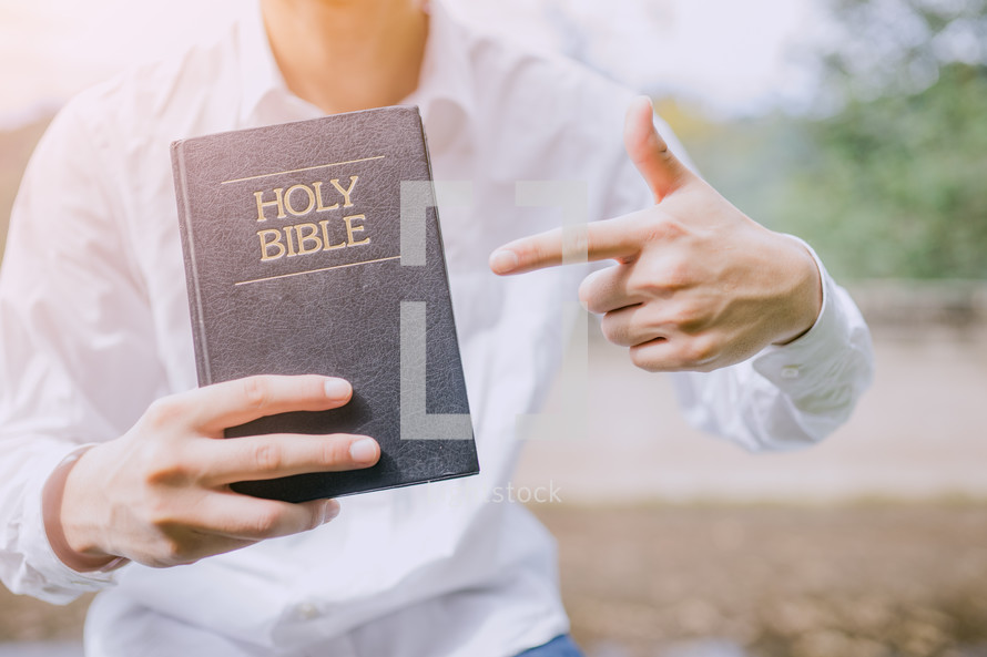 a man pointing to a Bible 