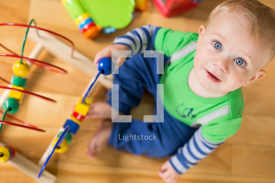 an infant playing with toys in a playroom