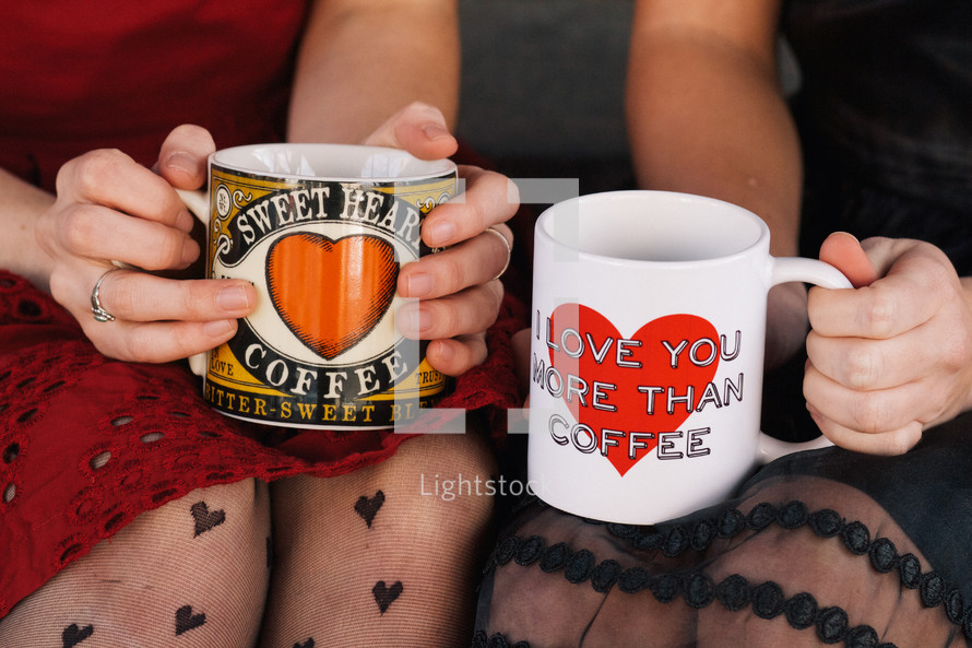 women holding coffee mugs with hearts 