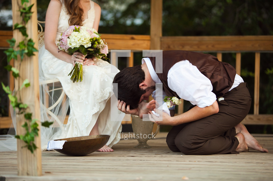 groom washing his brides feet.
