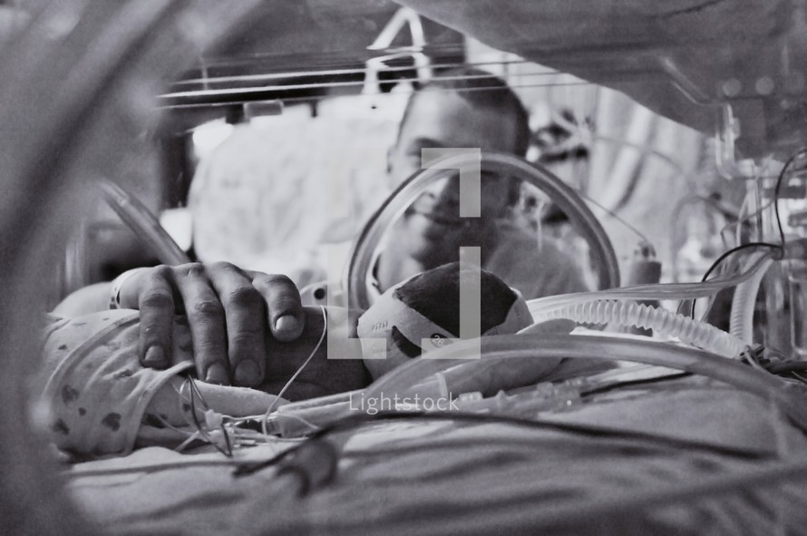 Father looking at premature baby