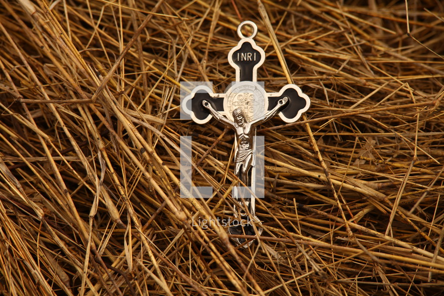silver crucifix necklace on straw
