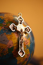silver crucifix on a globe 