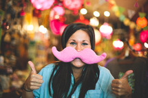 woman with a toy mustache 