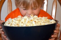 child and a bowl of popcorn 