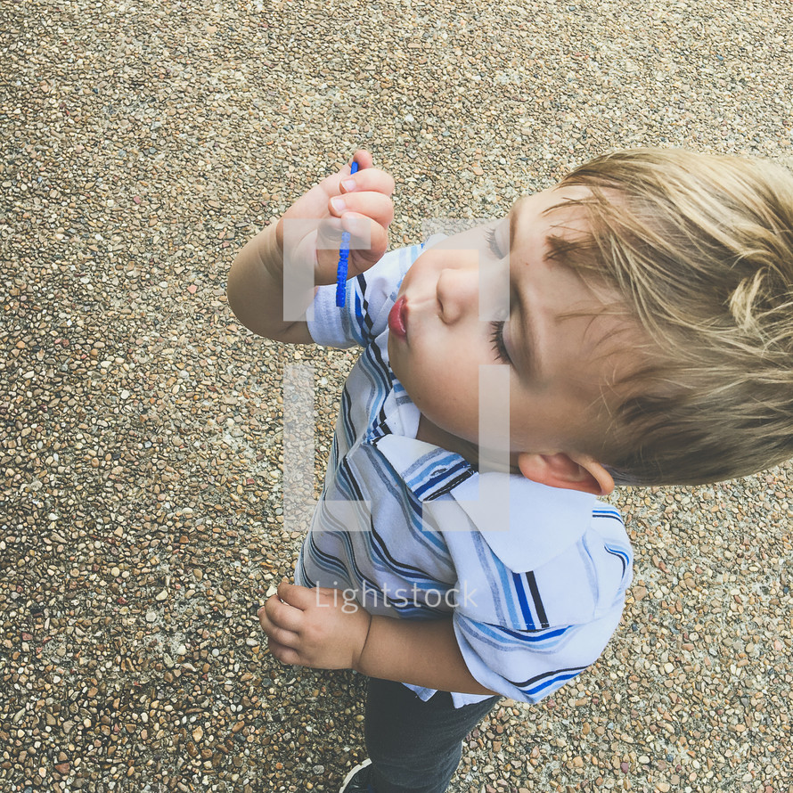 a toddler boy blowing bubbles 