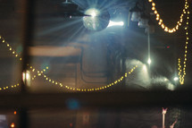 disco ball and strung lights over a dance floor 