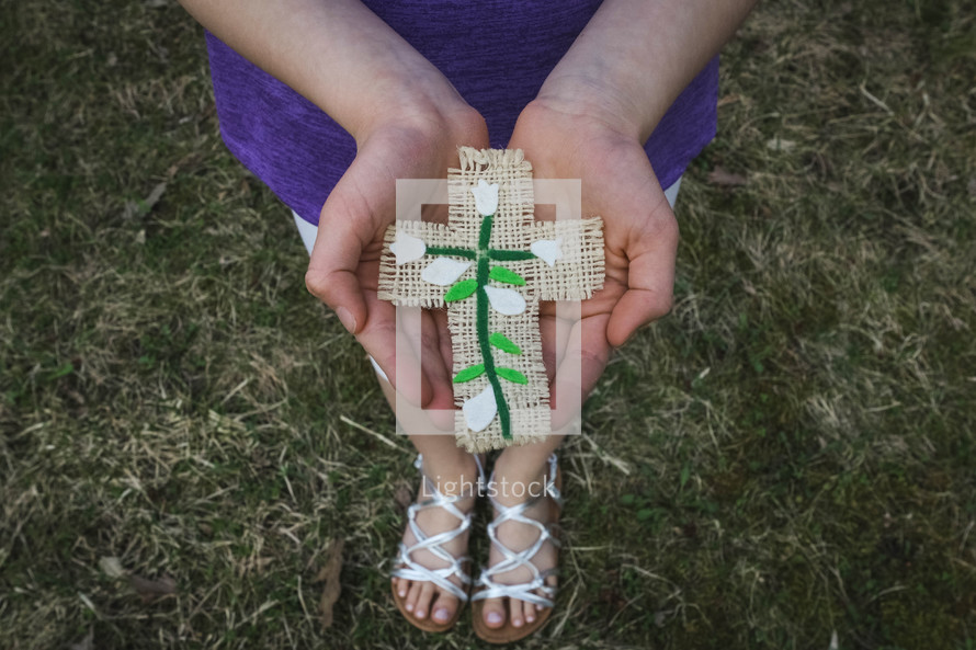 girl holding a handmade Easter cross craft