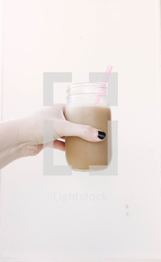 a hand holding chocolate milk 