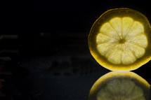 Slice of lemon with reflection.