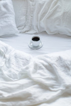 coffee cup on a bed 