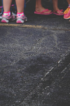 children's feet and shoes on asphalt 