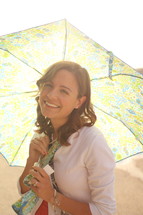 a young woman holding an umbrella to block the sun 