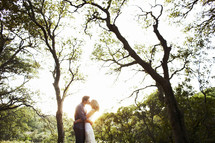 couple kissing under the trees