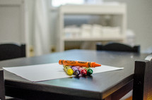 crayons on white paper on a table 