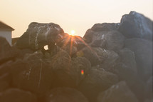 sun setting behind a rock pile 