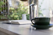 coffee cup and open Bible on a wood table 