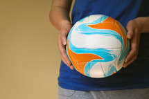 a woman holding a volleyball 