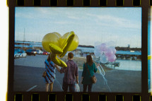 film of people walking with balloons 
