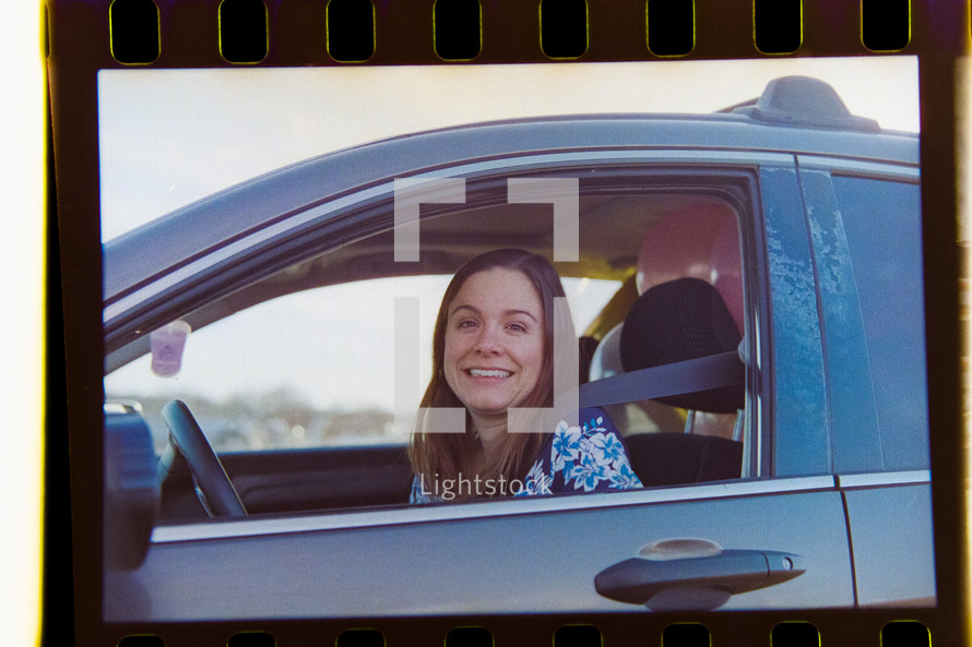 smiling woman in a car on film 