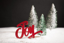 Christmas trees decoration with the word "joy" and snow