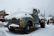 A vintage blue pickup truck in the snow