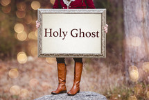 woman holding a sign that reads Holy Ghost 