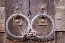 old rusty door pulls locked with chains 