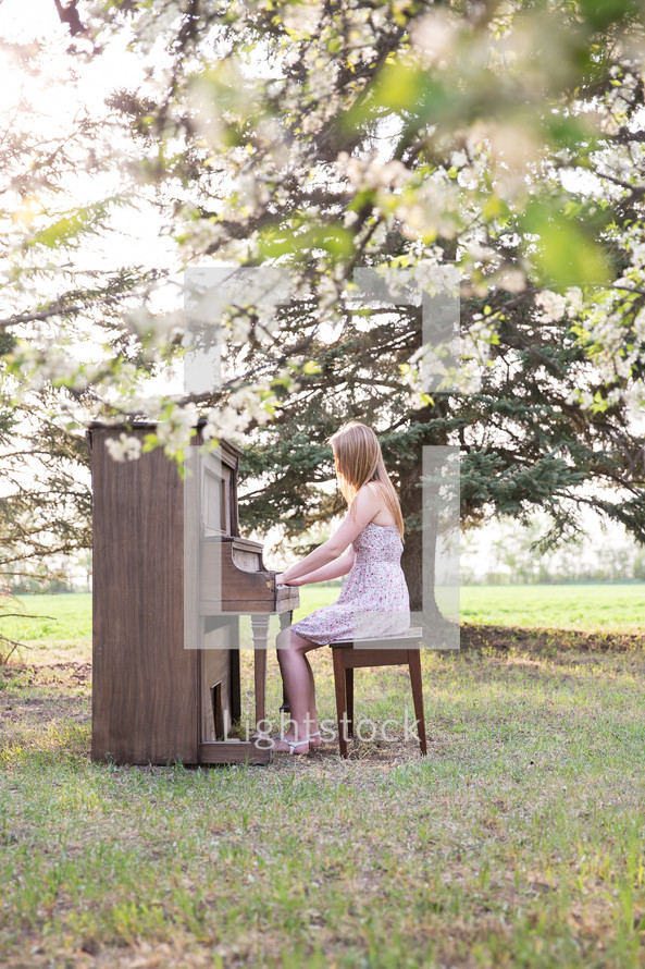 a woman playing a piano outdoors 