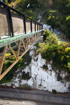 Seagulls perched on an industrial bridge in a rocky landscape