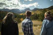 young adults standing in a valley 
