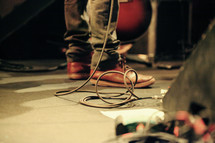 musician's feet among amp cords