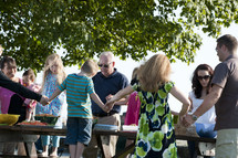 Family Saying Grace At Outdoor Picnic