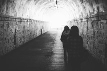 women walking through a tunnel 