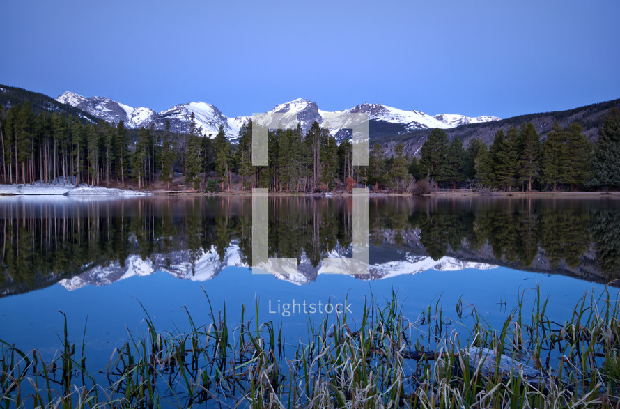 reflection of snow capped mountains in lake water 