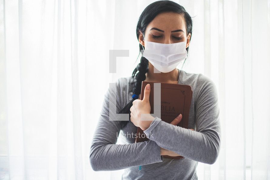 a woman holding a Bible praying 