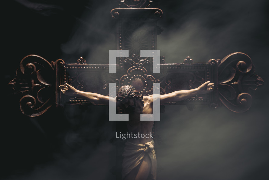 Jesus on a detailed wooden cross with smoke and moody lighting.