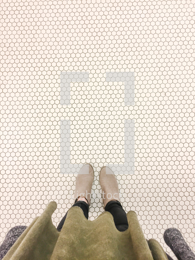 a woman standing on white tile floor 